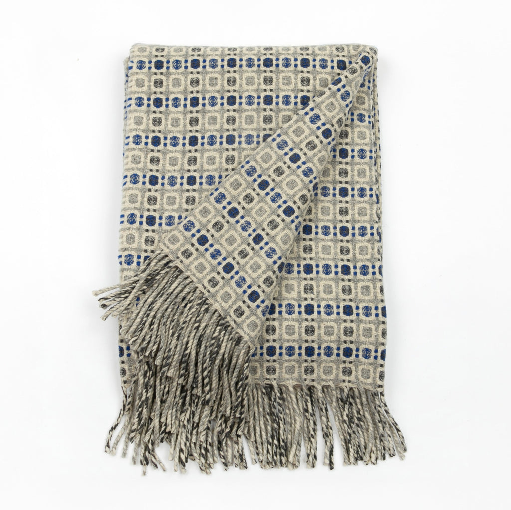 Patterned throw blanket with fringes on a white background
