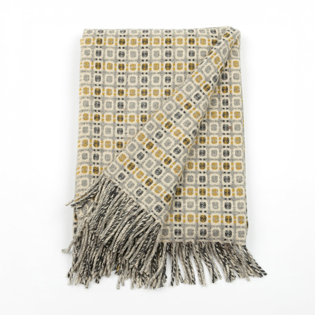 Patterned throw blanket with fringes on a white background