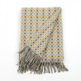 Patterned throw blanket with fringes on a white background