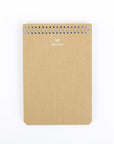 A beige, A6 medium-sized notebook with a stylized carrier pigeon logo on the cover, spiral bound.