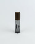 Small cylindrical container with brown top and black bottom on a white background
