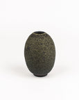 A small, rounded ceramic vase with a textured, speckled dark gray and black glaze, standing on a white background.