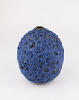 A small blue highly textured ceramic vase with a short neck, photographed on a clean white background.