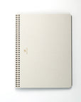 Beige spiral-bound notebook on a white background