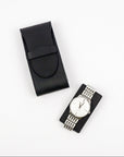 Black watch case with a silver watch on a white background