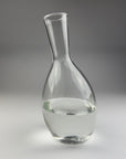 Clear glass carafe on a gray background