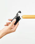 Hand holding a black lighter with a yellow candle on a white background