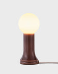 Table lamp with a brown base and white bulb on a light gray background