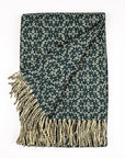Woven blanket with geometric pattern and fringes on a white background