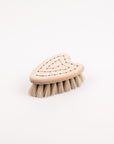 Heart shaped wooden brush with soft bristle head on a white background