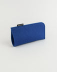 Blue felt eyeglass case with a brand label on a light gray background