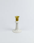 White candle holder with gold top on a white background