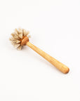 Wooden handled dish brush with natural bristles on a white background