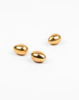 Three gold egg forms on a white background