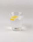 Clear glass with a lemon slice on a white background