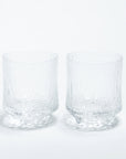 A set of two clear glass highball glasses with a geometric pattern.