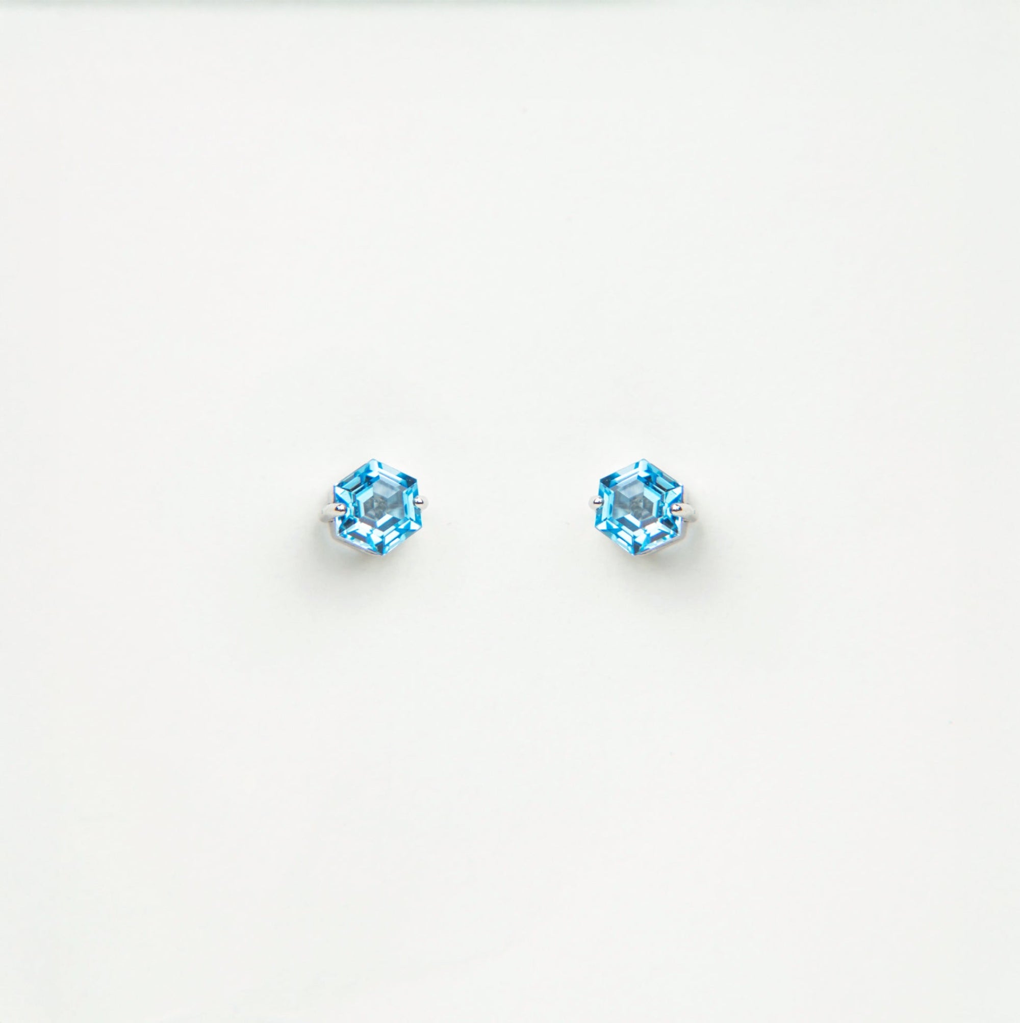 Pair of blue gemstone stud earrings on a white background