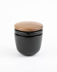 Black container with a wooden lid on a white background