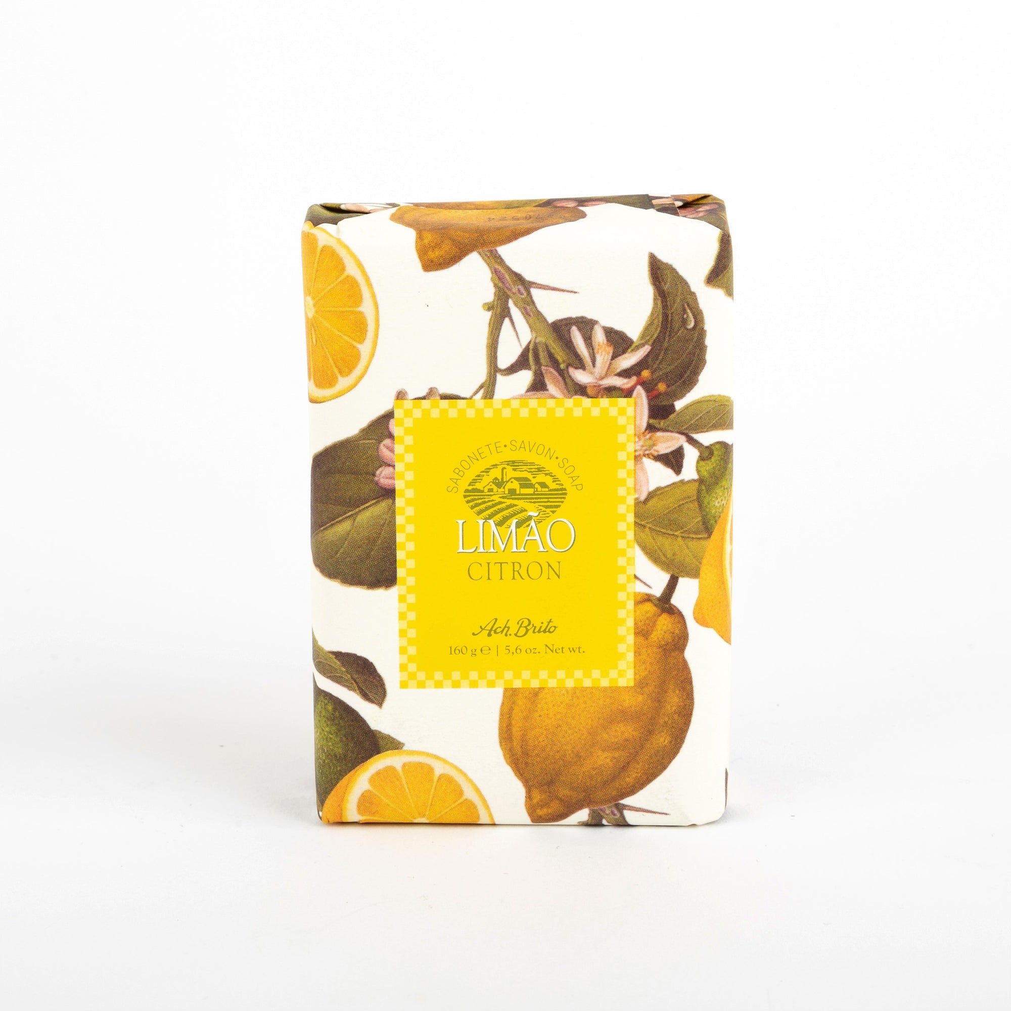 A packaged bar of Ach. Brito fruit and vegetable soap with a lemon scent, featuring an printed design with leaves and lemon slices, and a yellow label with the product name and brand.