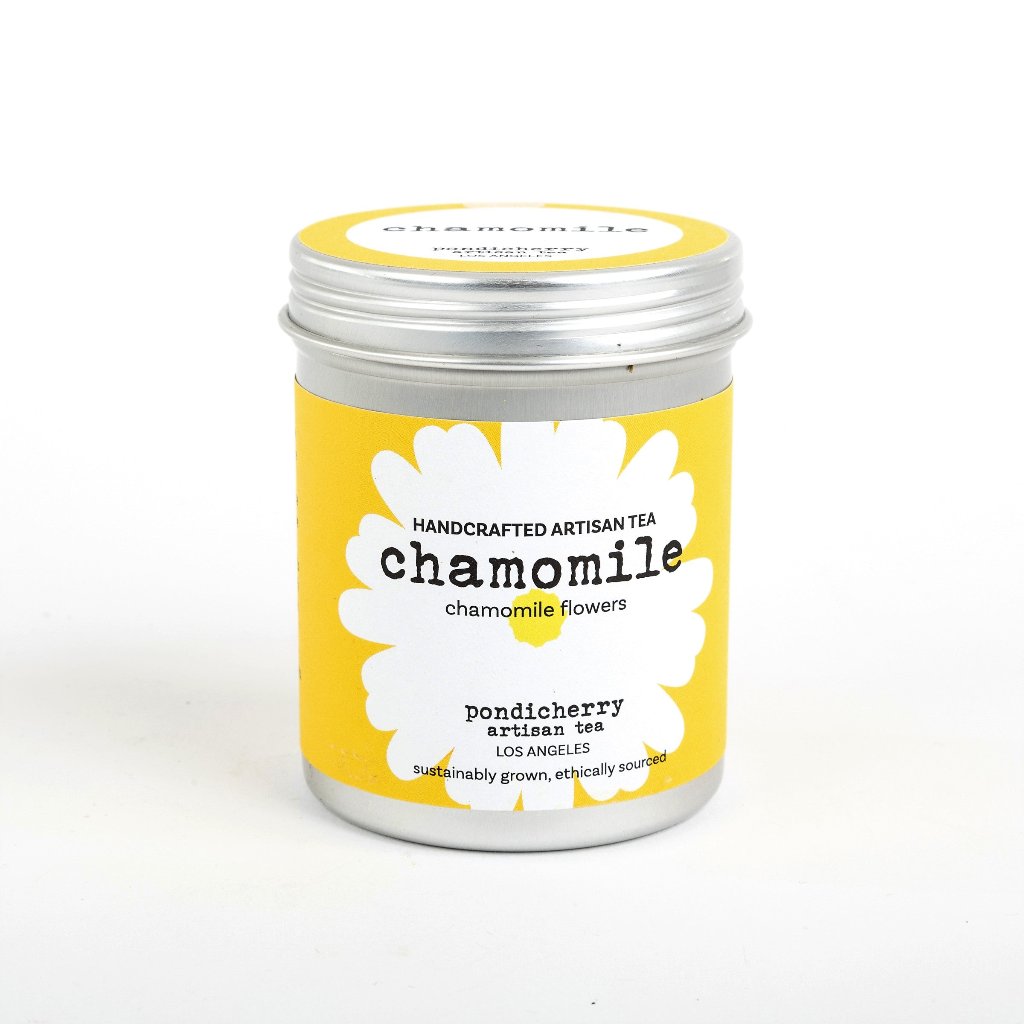 A canister of Pondicherry Dry Goods Chamomile Tea with a yellow label featuring white chamomile flowers and text.