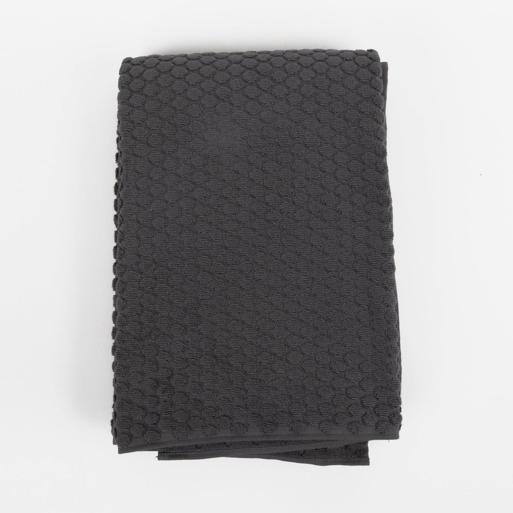 Dark gray textured bath towel on a white background