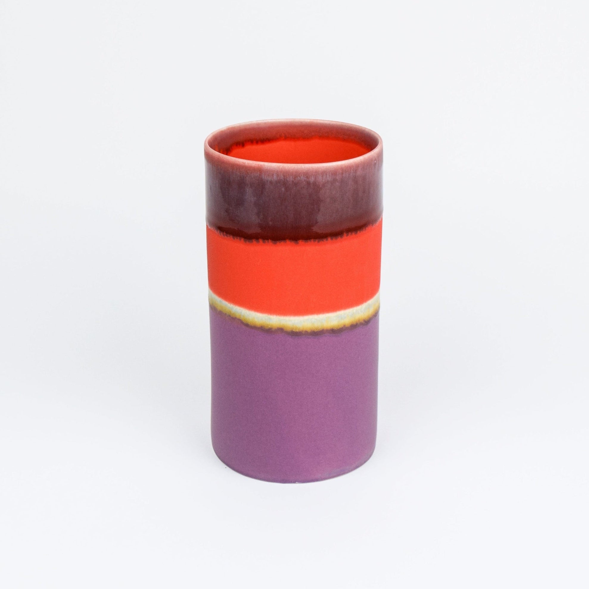 Cylindrical ceramic vase with a two-tone design on a white background