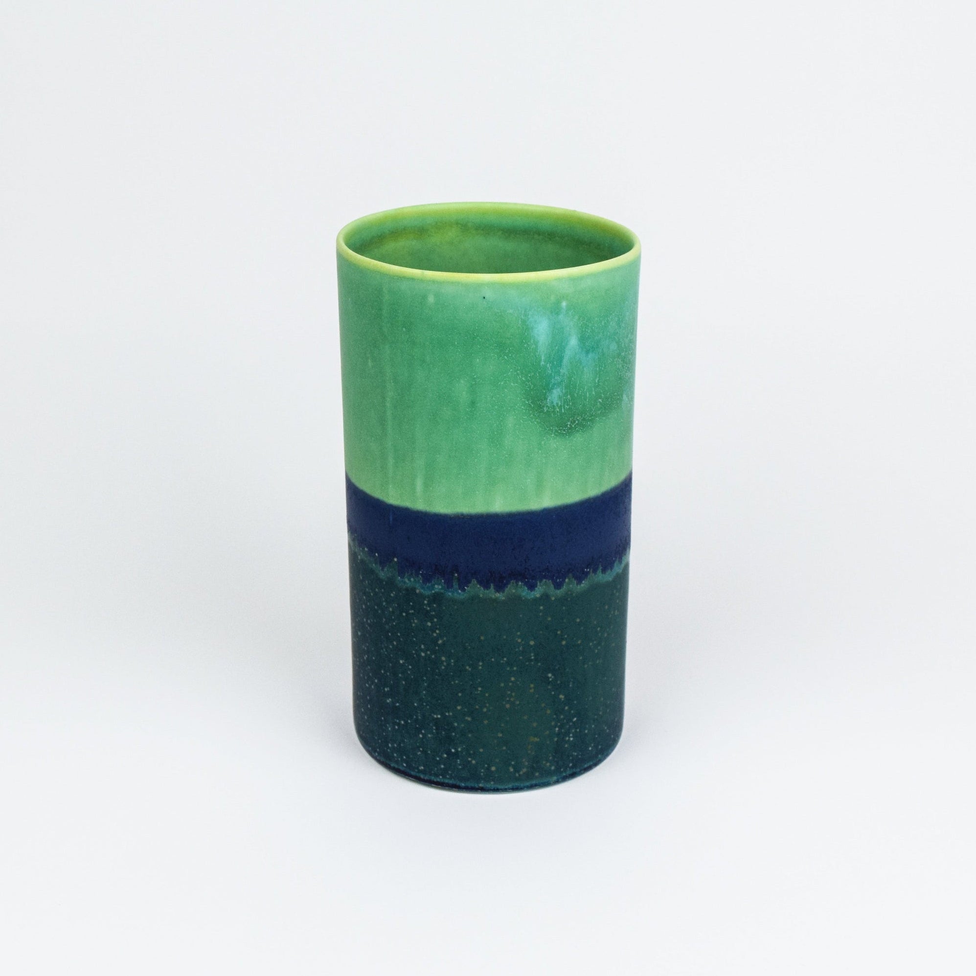 Green and blue ceramic vase on a white background