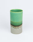 Green ceramic vase with a textured base on a white background