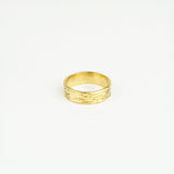 Gold ring with textured design on a white background