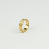 Gold ring with a textured design on a light gray background