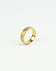 Gold ring with a textured surface on a white background
