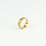 Gold ring with a textured surface on a white background
