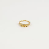 Gold ring with small beads on a light beige background