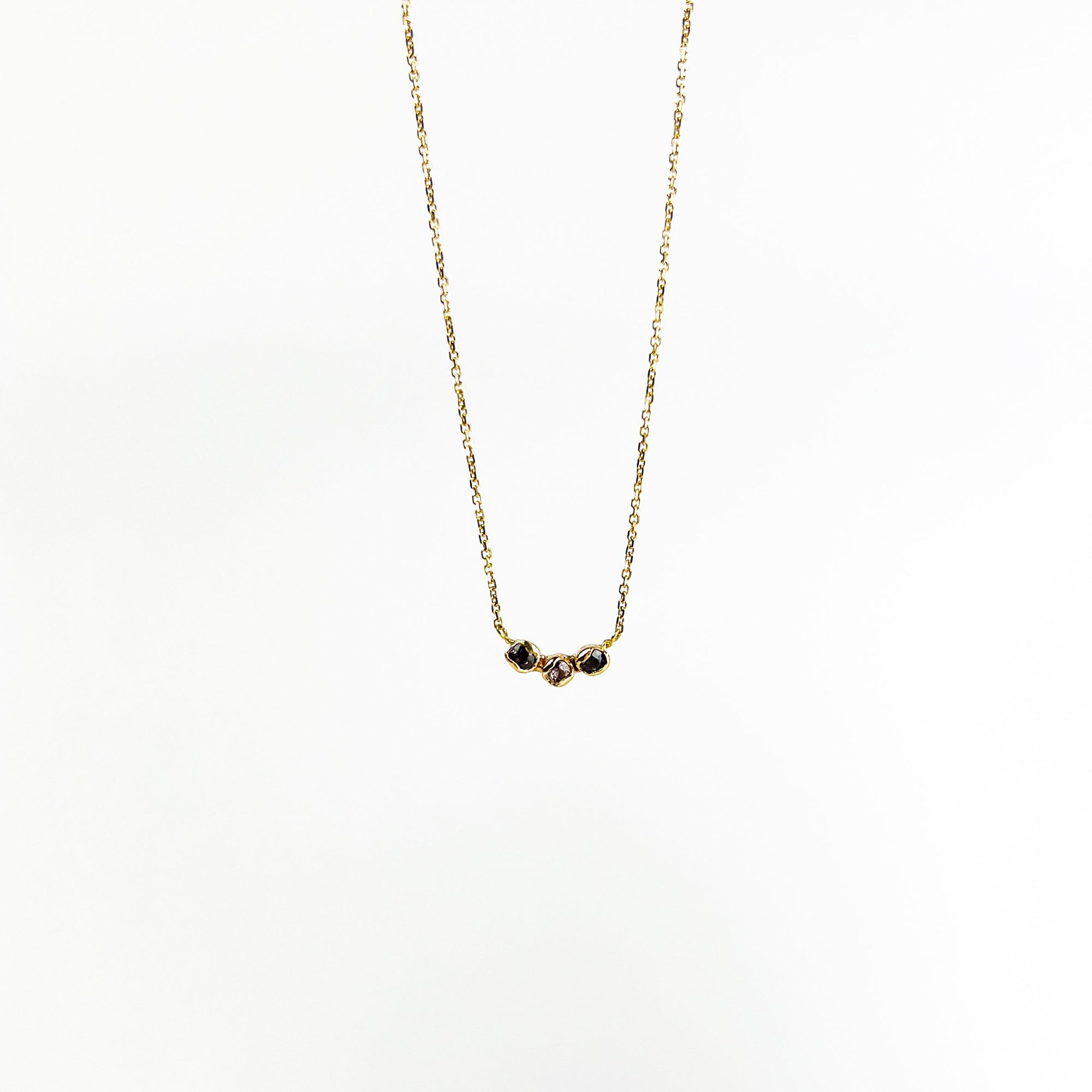 Gold necklace with small natural sapphires on a white background