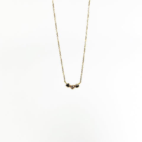 Gold necklace with small natural sapphires on a white background