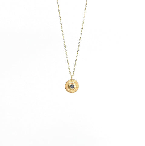 Gold necklace with a round pendant on a white background