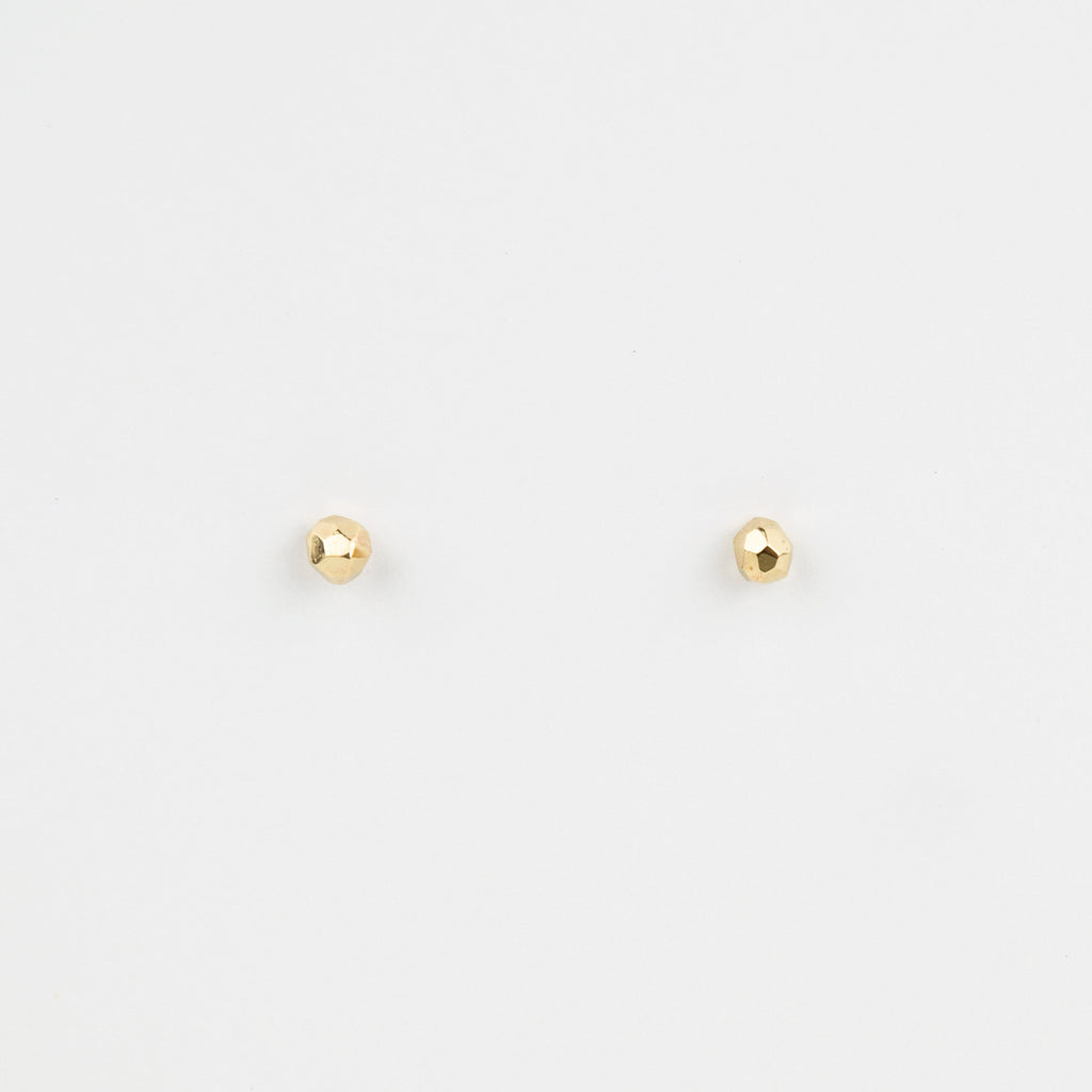 Two small gold studs on a white background