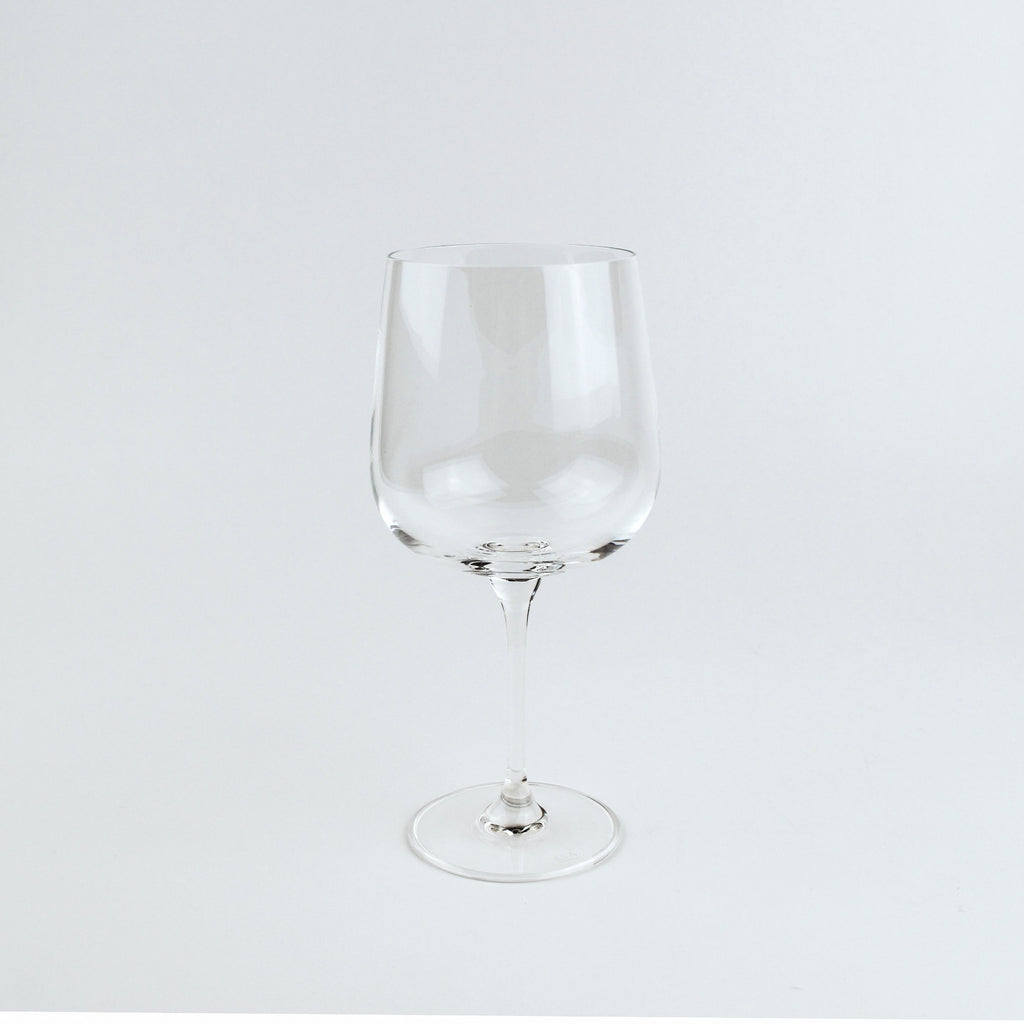 Clear wine glass on a light gray background