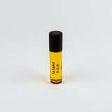 Small rollerball bottle with yellow liquid and black cap on a white background