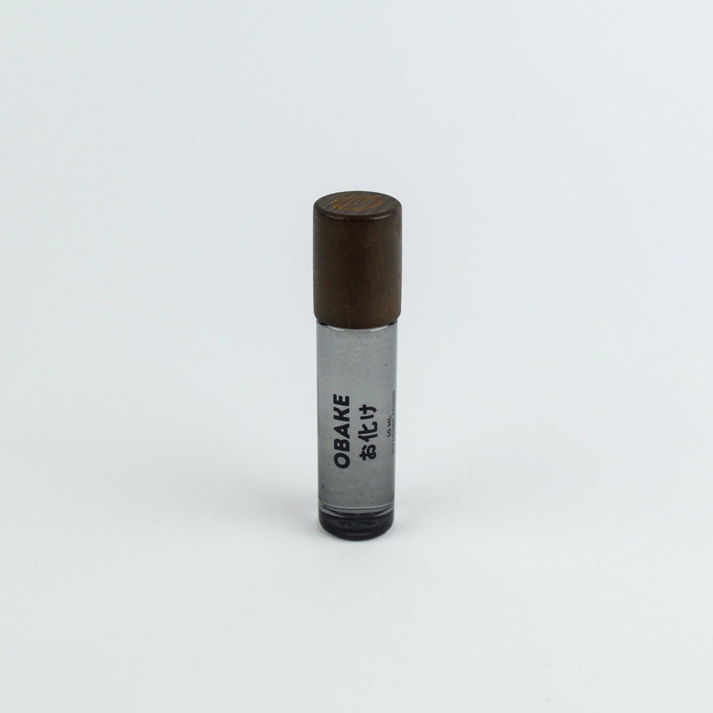 Small cylindrical container with brown top and black bottom on a white background