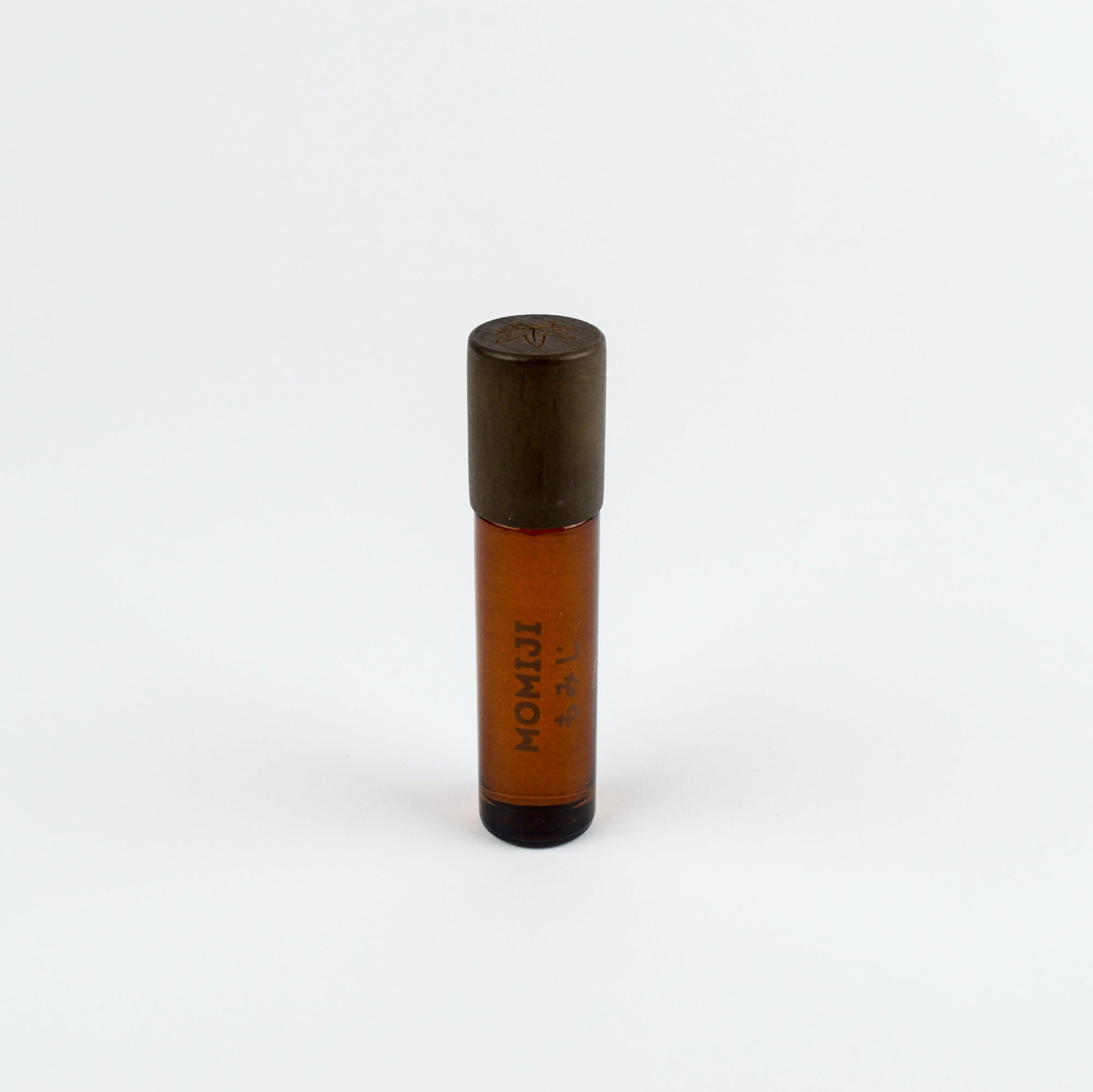 Small brown bottle with black cap on a white background