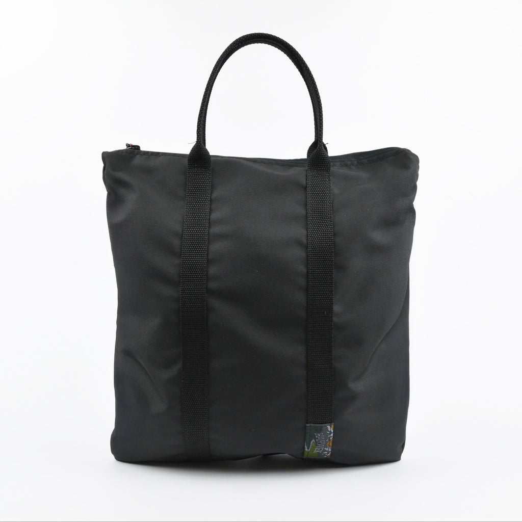 Black tote bag with straps on a white background