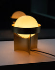 Modern table lamp with a spherical shade on a dark background