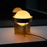 Modern table lamp with a spherical shade on a dark background