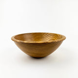 Wooden bowl with wavy texture on a white background