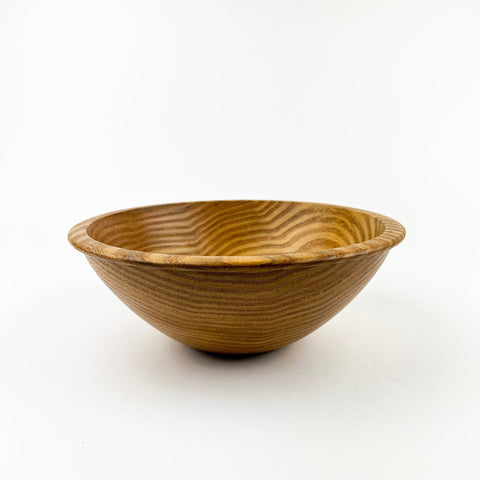 Wooden bowl with wavy texture on a white background