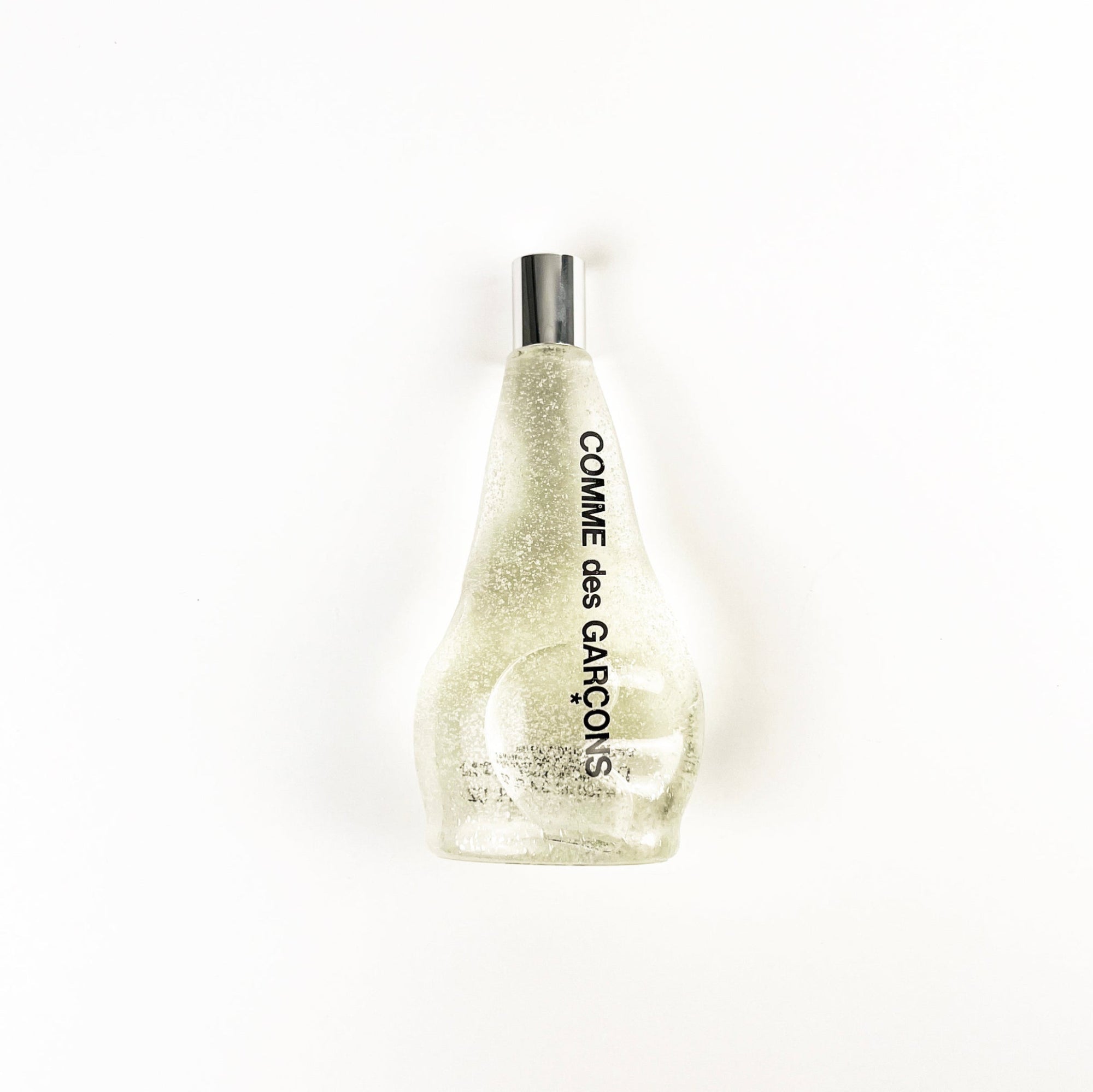 Comme des Garcons glittery perfume bottle on a white background