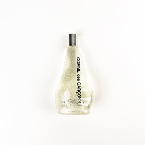 Comme des Garcons glittery perfume bottle on a white background