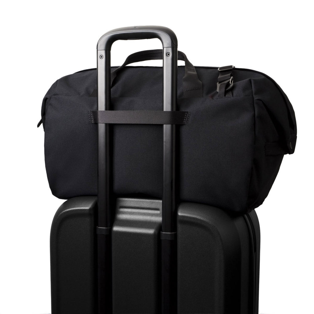 Black rolling suitcase with a black duffel bag on top