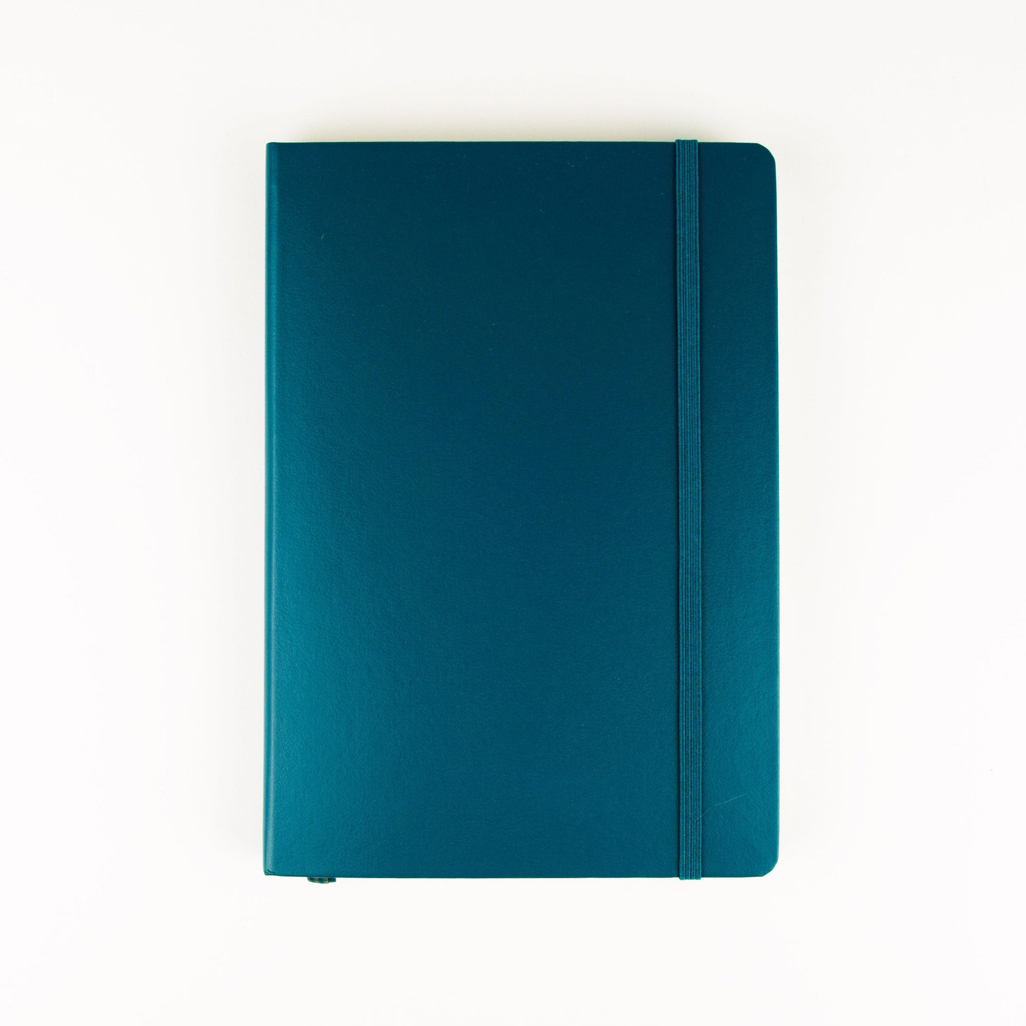 A teal blue hardcover notebook with a matching elastic closure band, photographed flat against a clean white background.